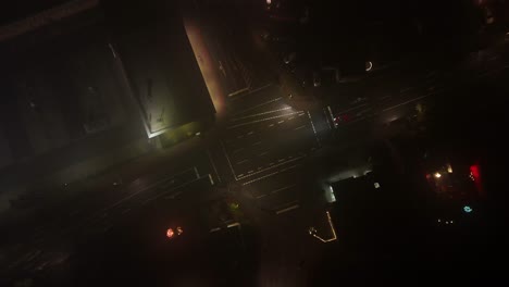 aerial top down rising shot of car on junction of small american town. clouds and fog hovering in sky. houses and homes in suburb area of usa.
