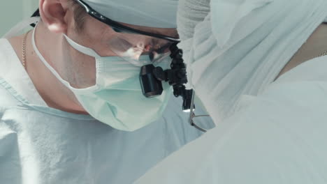 man surgeon with assistant operates. focused medics in uniform attentively examine patient preparing for complicated surgery in operating room