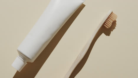 close up of toothbrush and toothpaste on beige background