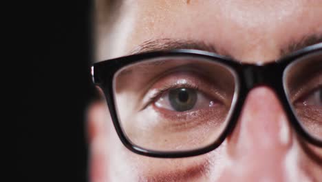 close up portrait of face of caucasian man wearing glasses with focus on eye