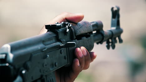 an army soldier holds a gun in his hand