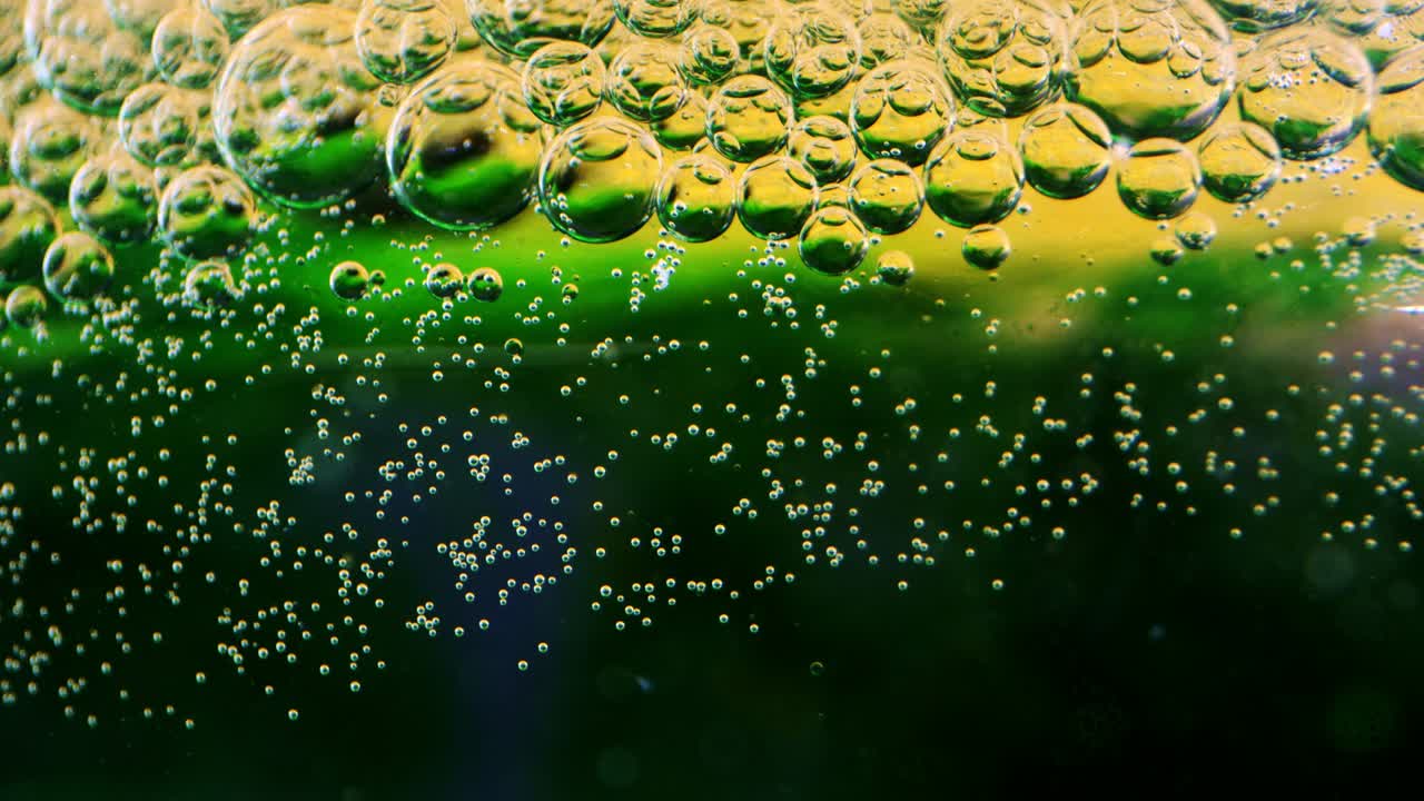 유리 뒤에 잉크가 있는 기름과 물에 있는 거품