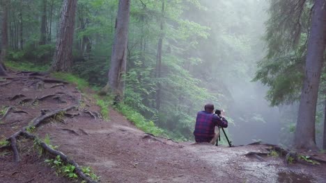 photographer in a misty forest