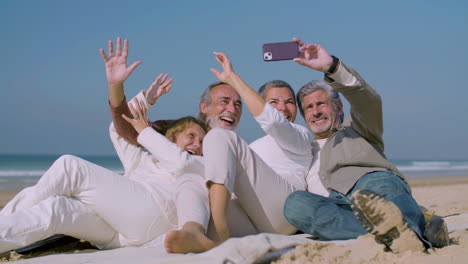 happy senior people lying on beach and taking selfie on phone