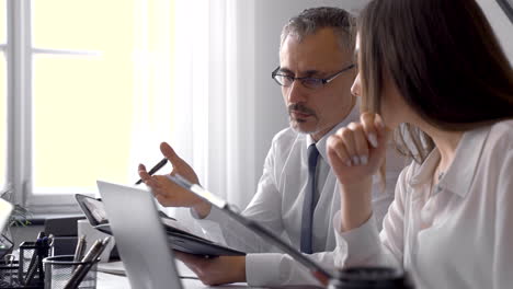 Two-Co-Workers-Talking-About-Business-And-Checking-Important-Documents