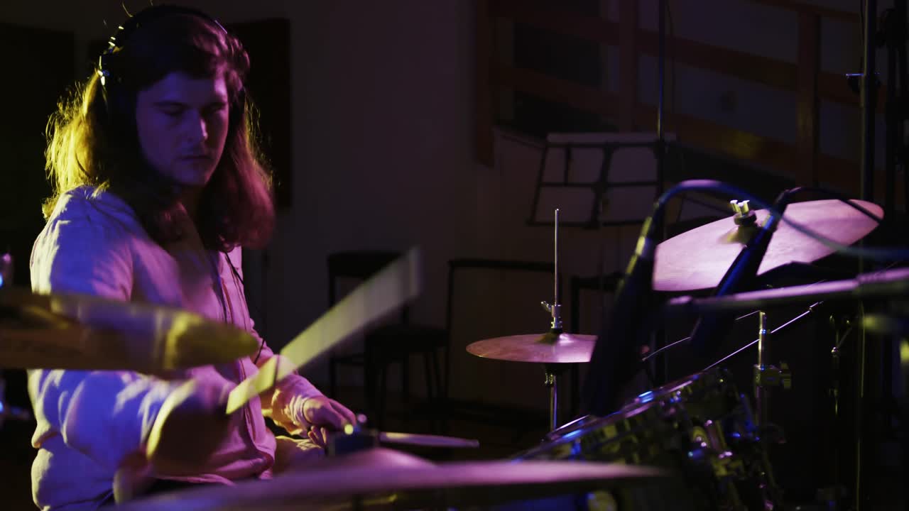 Uomo che suona la batteria in uno studio musicale