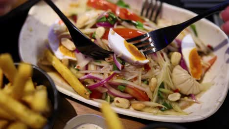 ensalada y papas fritas servidas con huevo hervido