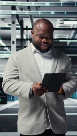 vertical video happy engineer walking in data center refining algorithms on tablet