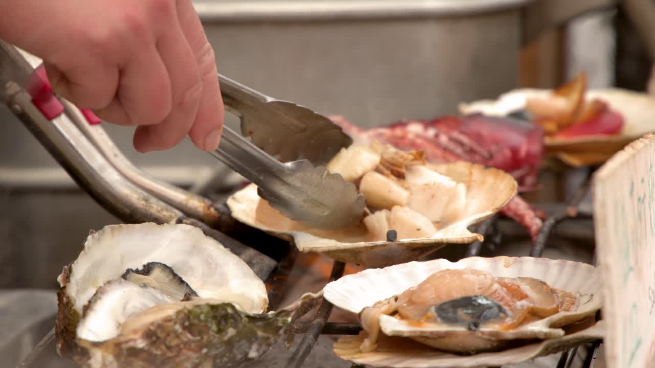 Close-up shot of a vendor using tongs to grill fresh seafood at a Japanese market