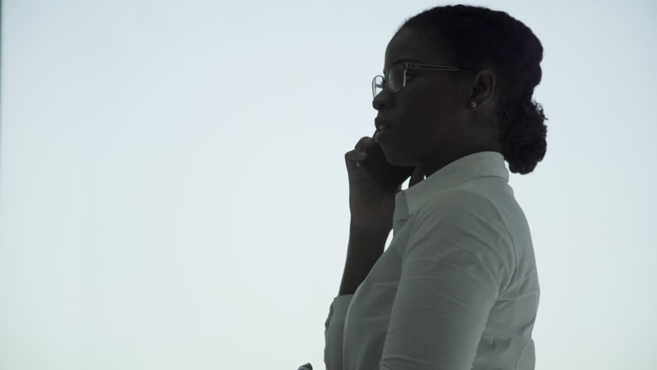 Smiling young businesswoman talking by cell phone