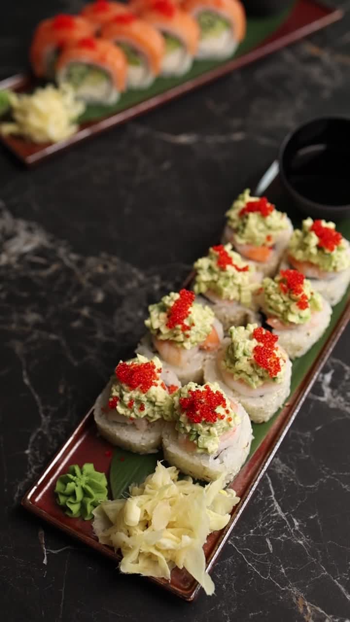 Sushi roll gourmet con avocado e uova di pesce rosse su un tavolo scuro