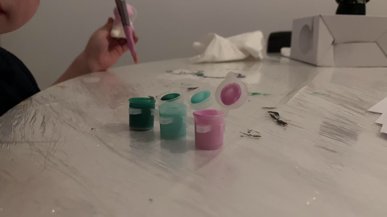 The boy soaks the brush in the paint container. Painting at home. Children's fun.