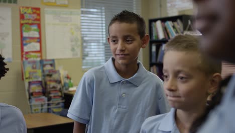 primary or elementary students in uniforms listen to teacher give instructions