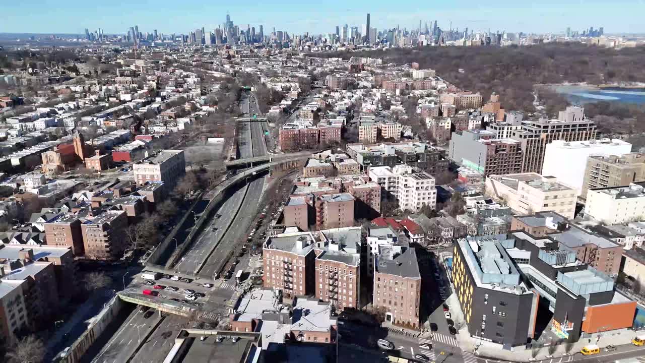 Horizontal drone side-tracking shot over Ocean Parkway in Brooklyn, capturing New York’s vibrant streets, residential buildings, and dynamic cityscape with smooth lateral aerial movement.