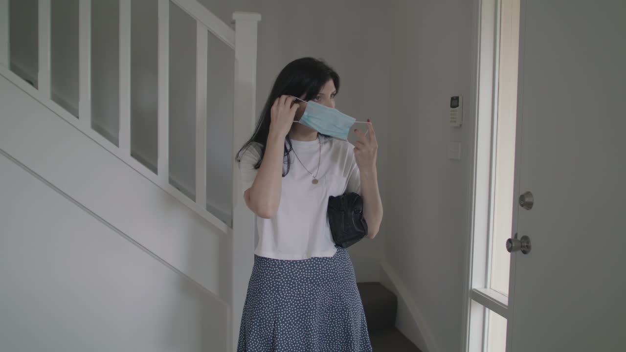 마스크를 쓰고 집을 떠나는 캐주얼 여성