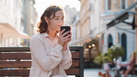 joyful woman enjoying drinking morning aroma coffee hot drink relaxing taking a break in city street