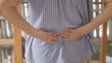 close up of old woman hands grabing on hurt lower back