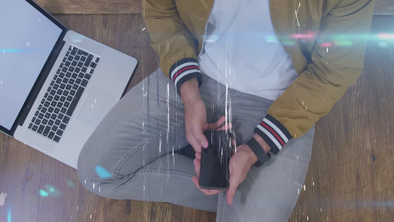 Animation of shapes over midsection of caucasian man using laptop and smartphone with copy space