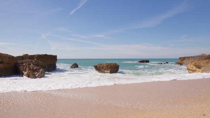 Vagues puissantes s'écrasant contre les rochers sur la plage en Algarve, Portugal