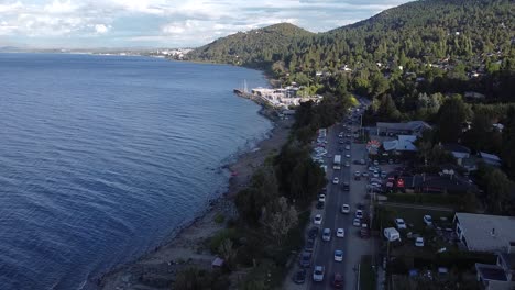 coastal area next to the sea or water with a road next to it with cars driving by