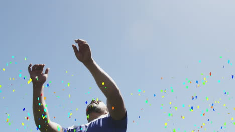 colorful confetti falling against male soccer player heading the football