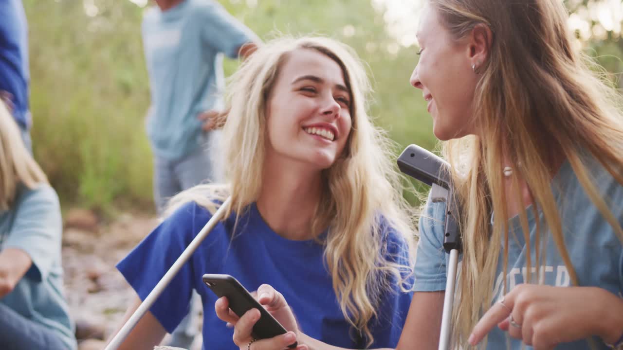 중년 성인 들 이 자원 봉사 하고 여자 들 이 강 을 청소 하는 날 에 웃고 있다