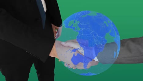 Globe-over-mid-section-of-two-businessman-shaking-hands-against-green-background