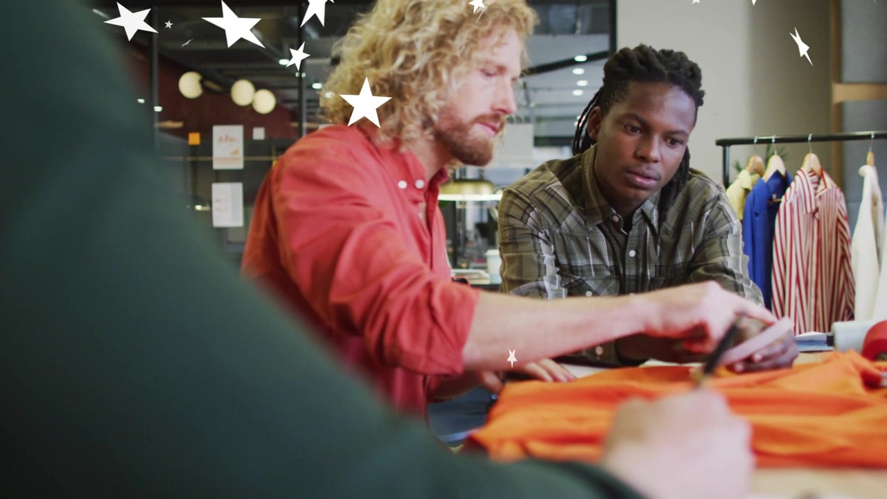 Designers marking orange garment and consulting swatch, star overlay aiding selection across pair