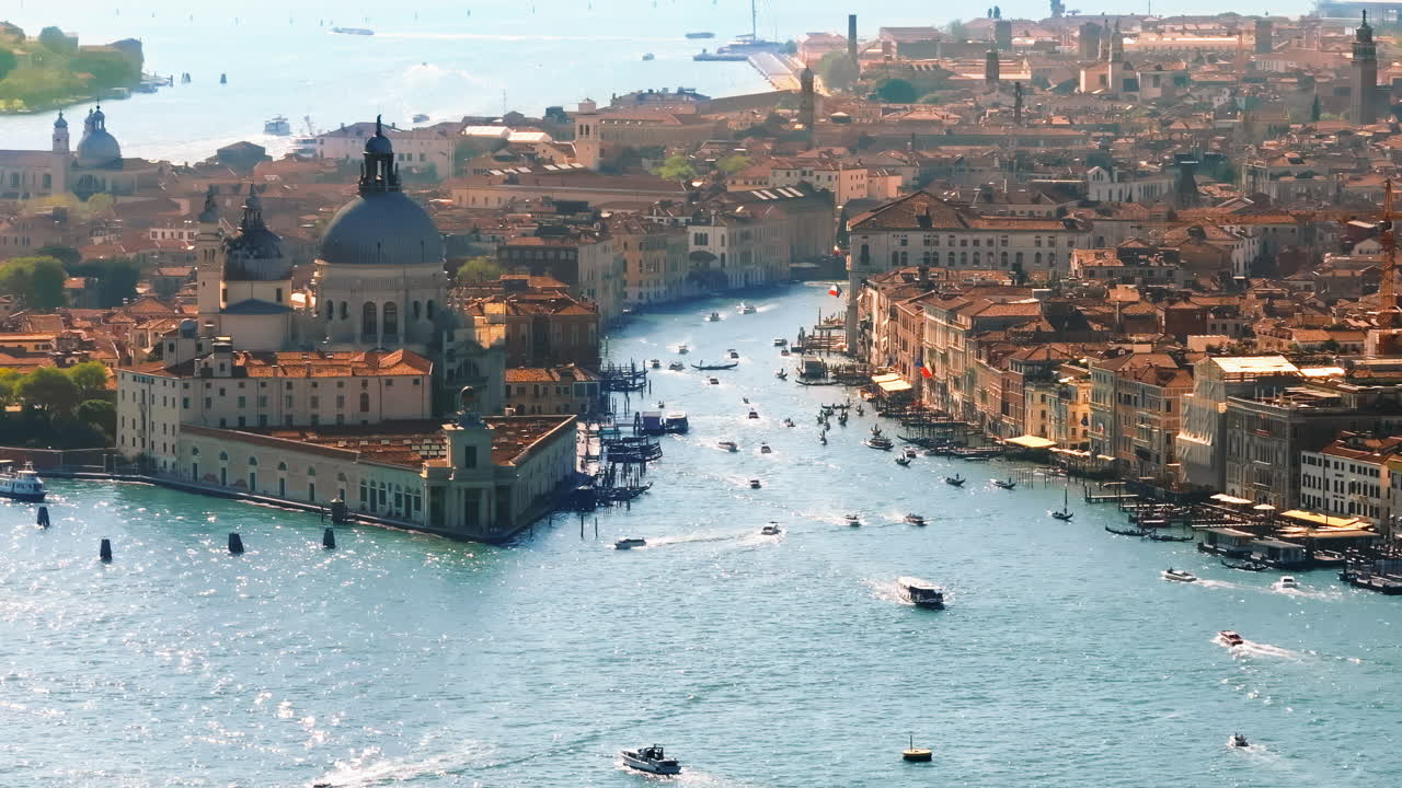 Aerial drone view of boats moving through Venice City, Italy on a sunny day
