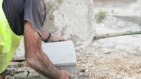 trabajador de la construcción tiene un ladrillo de hormigón en obras viales