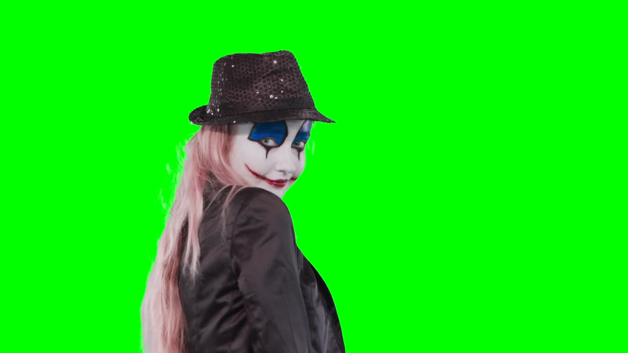 The girl clown poses laughing at the camera.