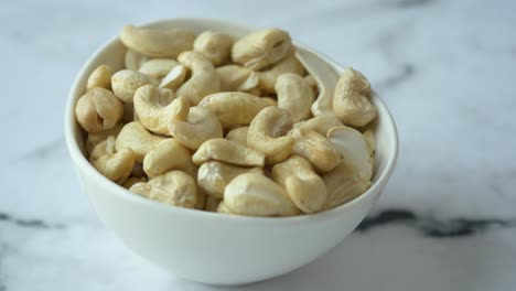 hand picking cashews from a bowl