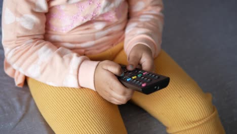 toddler watching tv with remote control