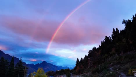 magnífico doble arco iris en el cielo al anochecer sobre el bosque y las montañas junto a walter peak en queenstown