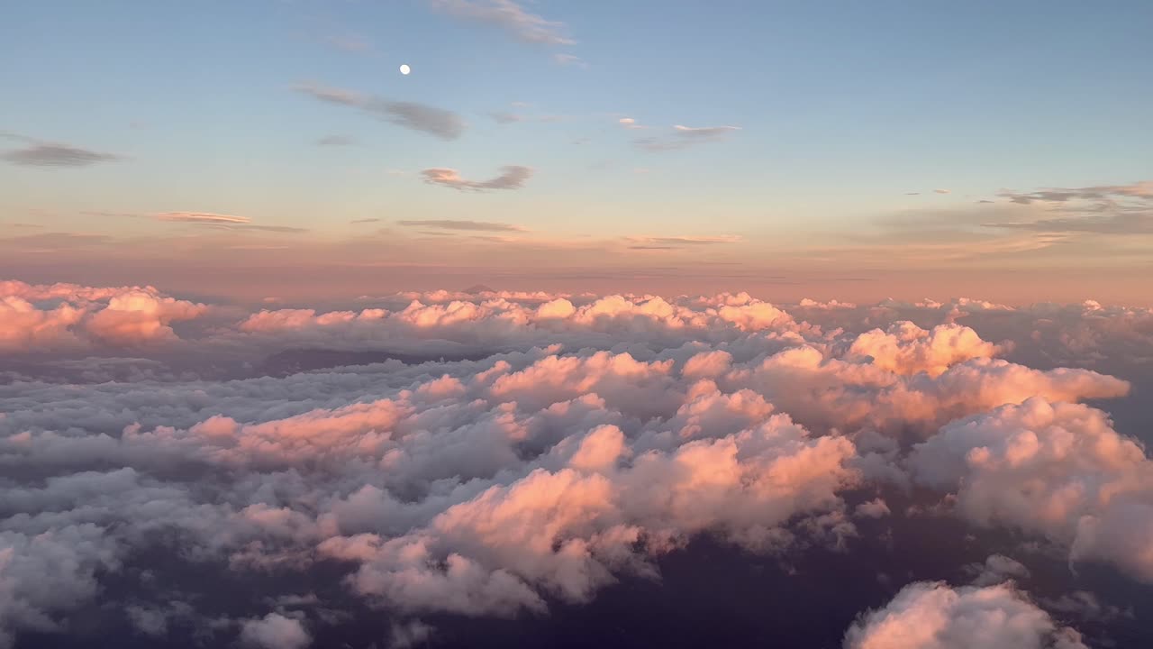 Vista frontale dalla cabina di un aereo commerciale in volo al tramonto sopra le nuvole