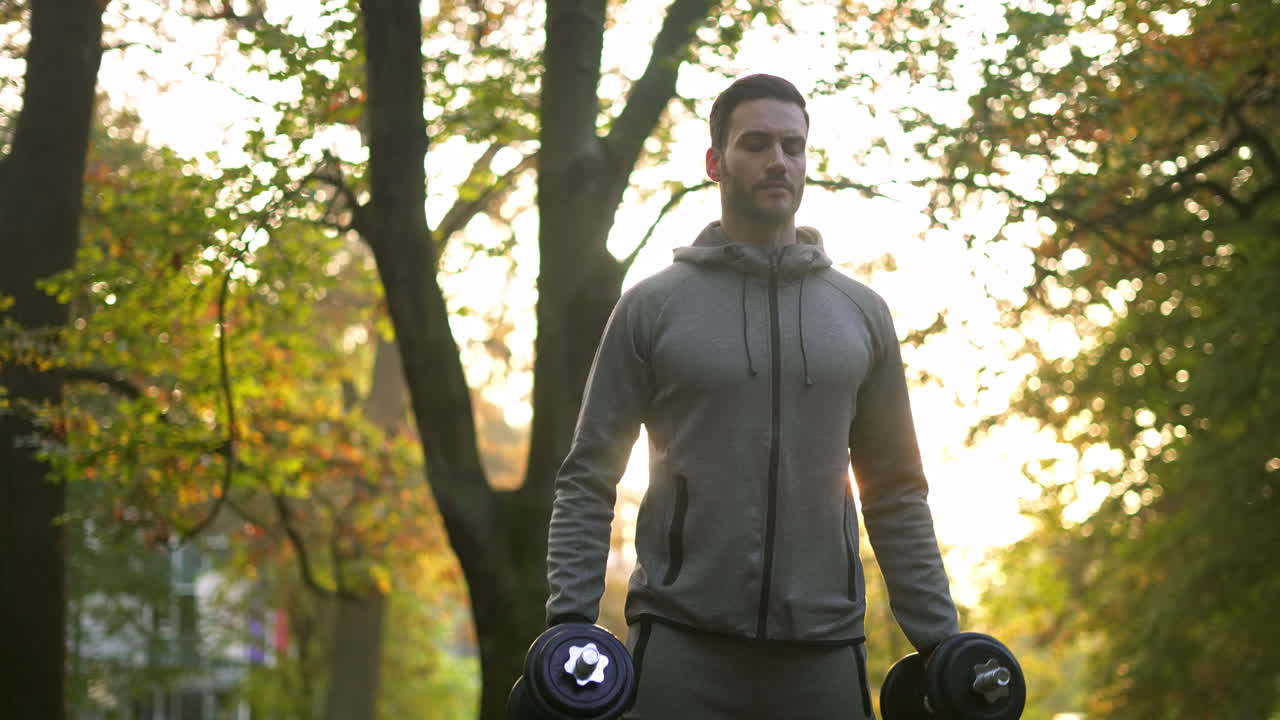 Man exercising with dumbbells in the park