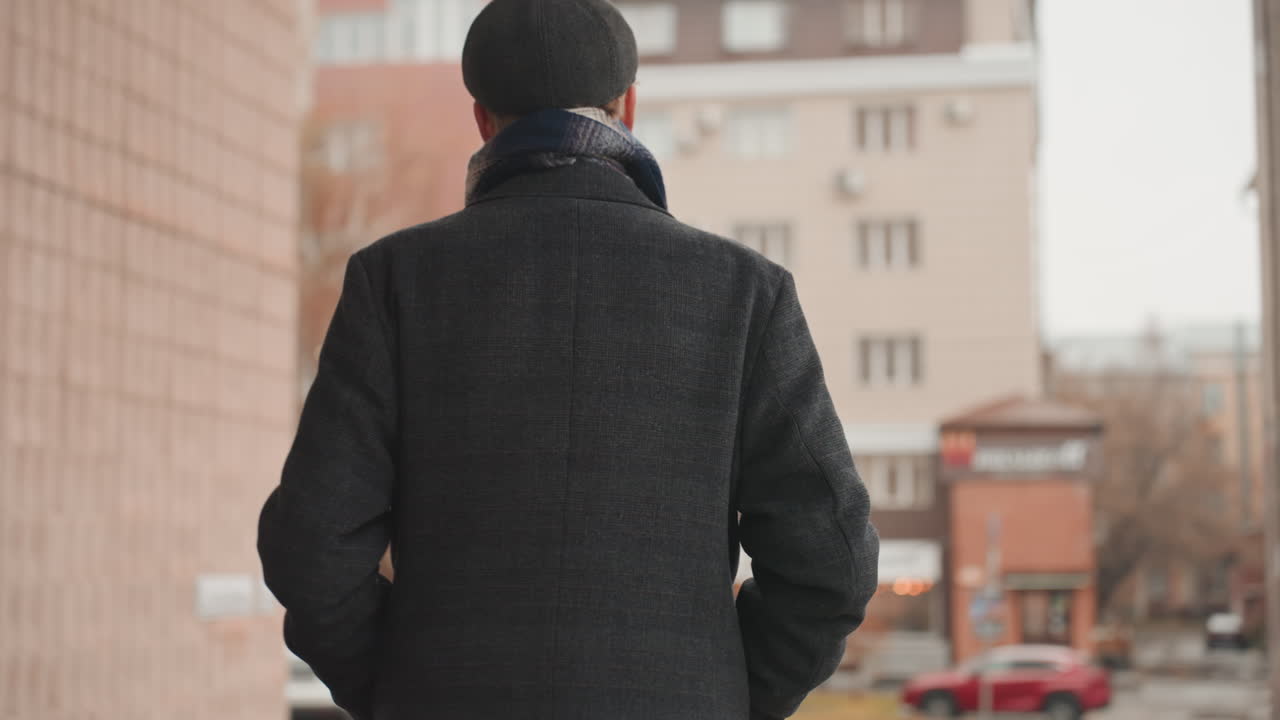 City traveler strides past pillars purposefully. Narrative of farewell depicted with cinematic city walk scene. Purposeful departure captured in cinematic cityscape with coat and scarf