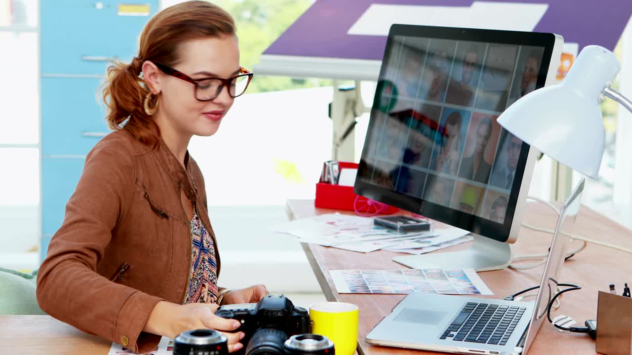 mujer ejecutiva revisando fotografía capturada en su escritorio 4k