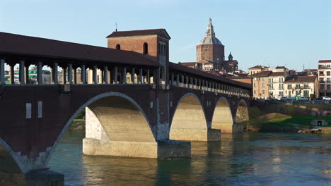 nice panorama of pavia , ponte coperto is a bridge over the ticino river in pavia at sunny day, pavia cathedral background, italy