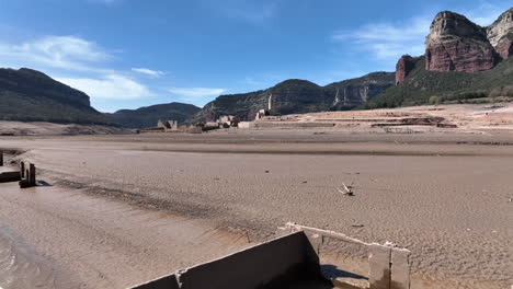 old building remains appears on lake coastline after heavy drought, aerial drone view