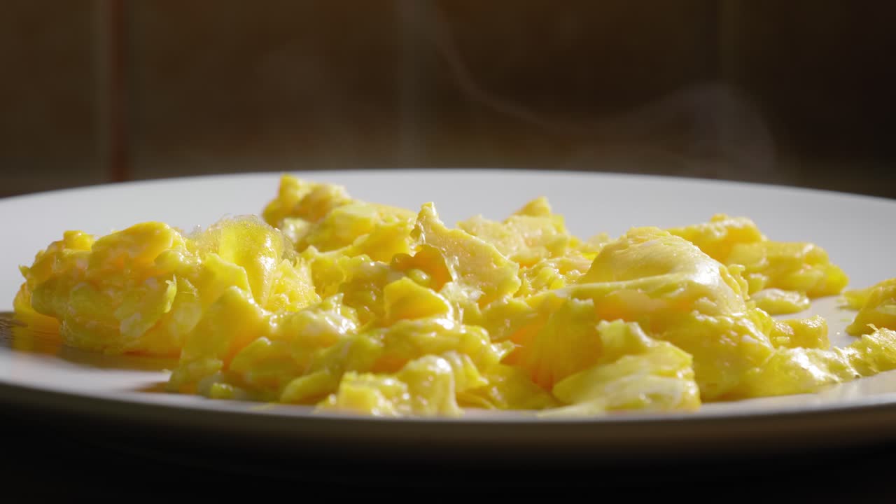 Smoking Hot Scrambled Eggs On a White Plate - Steady Shot