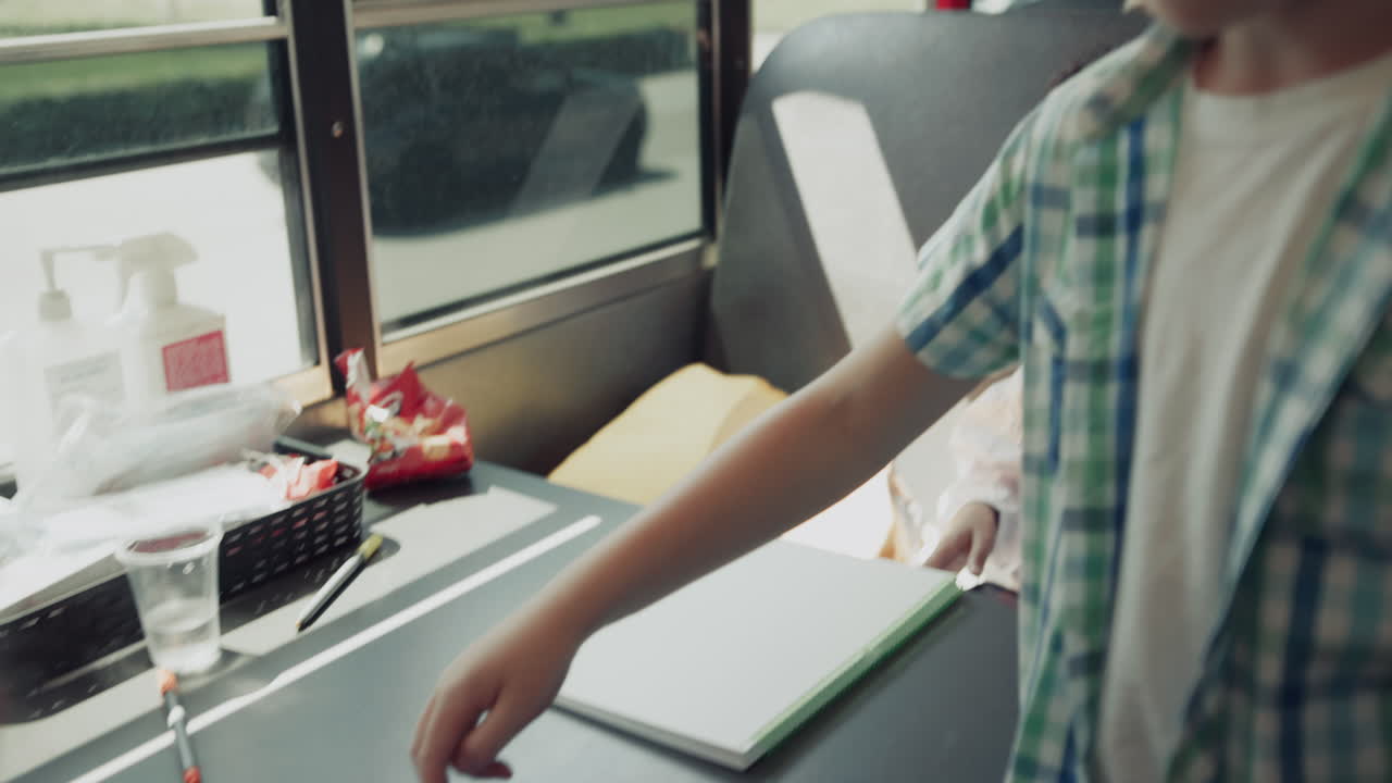Diverse multi-etnische kinderen zitten in schoolbus. Kinderen spelen en zwaaien naar de camera.
