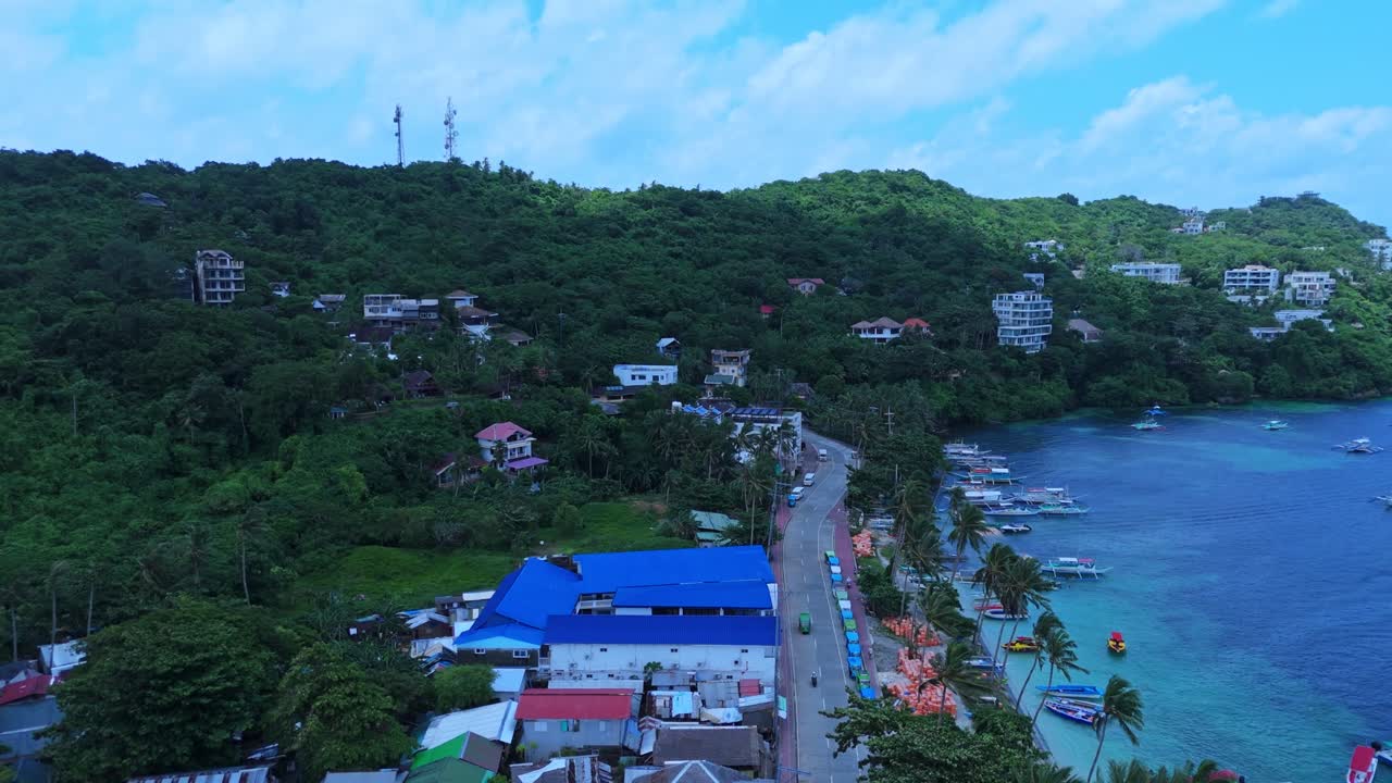 Breathtaking aerial of Boracay—lush hillside homes, palm-lined coast, and boats on turquoise water. Ideal for travel, tropical lifestyle, and tourism content