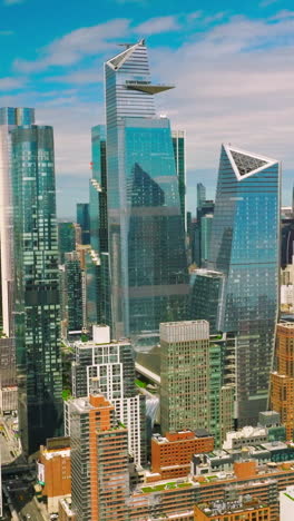 azure sky reflecting in the mirror windows of skyscrapers. new york city diverse architecture on beautiful sunny day. vertical video