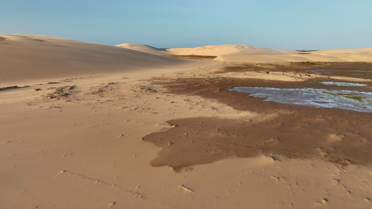 Golden Hour Desert Landscape with Water Patches - Aerial Flyover