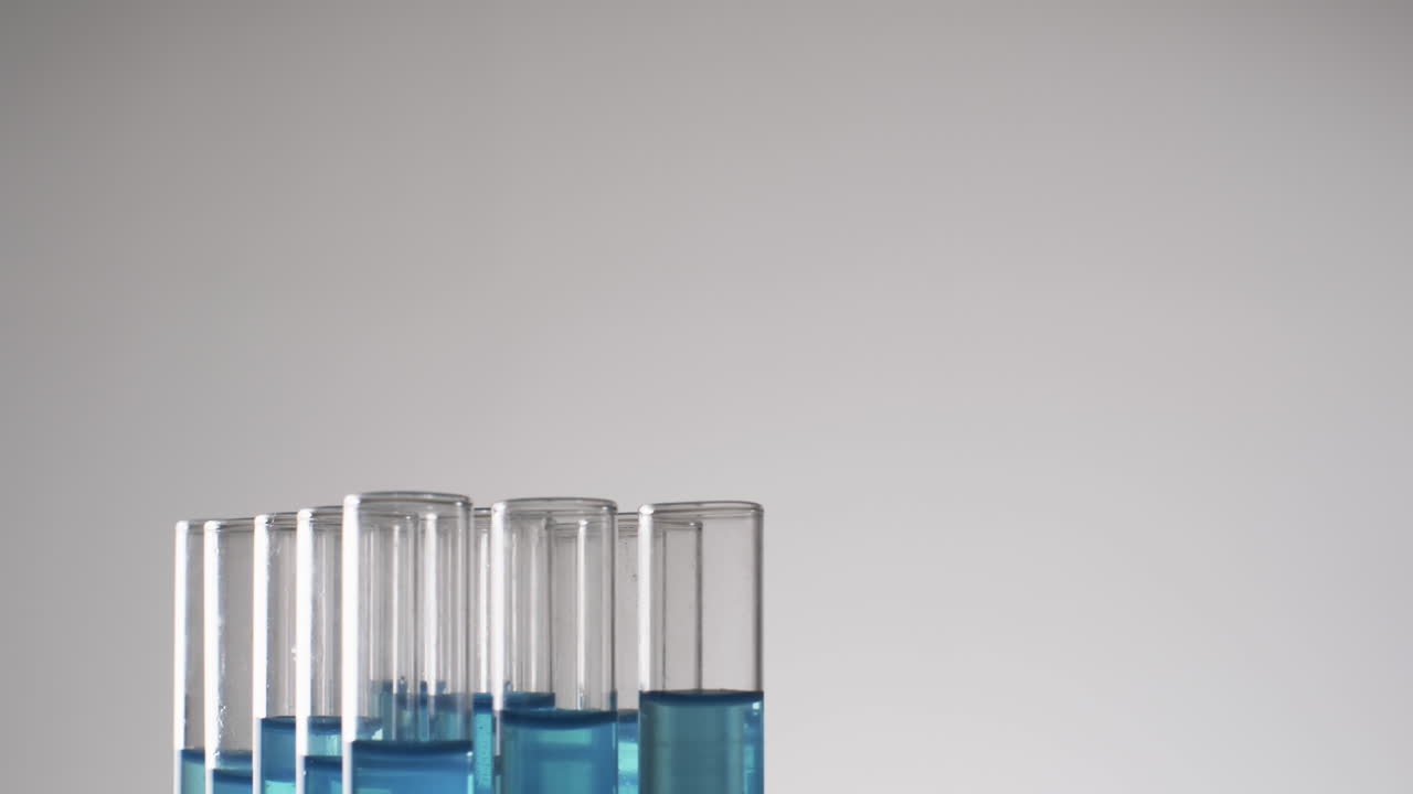 vídeo de tubos de ensayo de laboratorio de vidrio con líquido azul con espacio de copia sobre fondo blanco