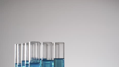 Video-of-glass-laboratory-test-tubes-with-blue-liquid-with-copy-space-on-white-background