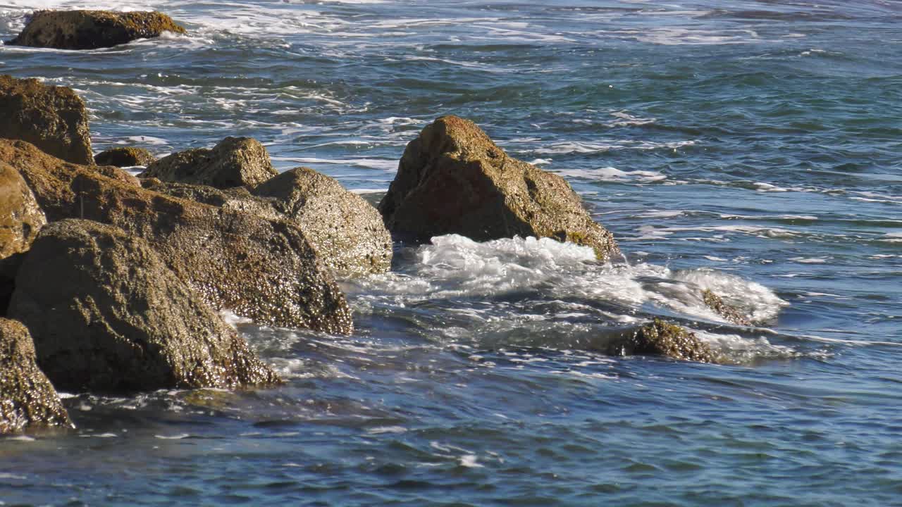 olas del océano azul rompiendo en las rocas, cámara lenta, españa