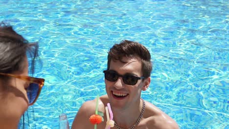 young adult couple flirting and talking in the swimming pool