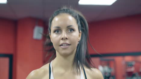 closeup-smiling-young-woman-runs-on-treadmill-in-sport-club